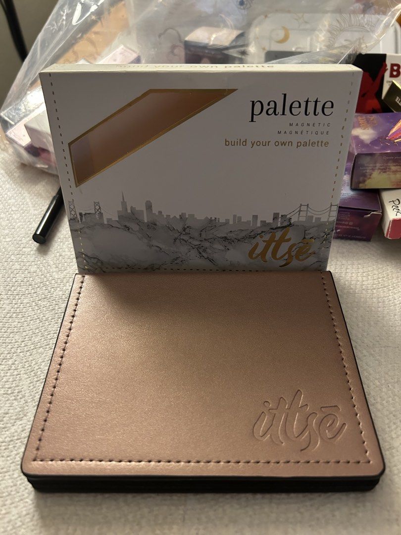ittse Magnetic Palette with Eyeshadows (Category: Makeup) located in Angeles City. Submitted by mycl0set (Listing ID 1438137192, Image 1). Description: - Rose gold ittse magnetic palette - Features four eyeshadow shades: light beige, grey, shimmery taupe, and dark brown - Includes a built-in mirror - ittse logo embossed on the front.