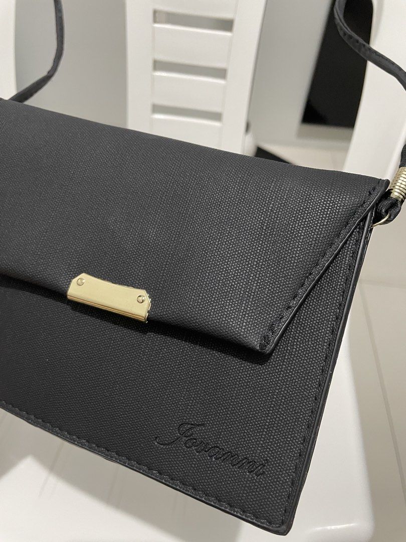 Jovanni Black Crossbody Bag (Category: Cross-body Bags) located in Taytay. Submitted by annequeen88 (Listing ID 1438224603, Image 2). Description: - Jovanni black crossbody bag - Flap closure with gold-colored accent - Long, thin strap for shoulder or crossbody wear - Multiple interior compartments - Made of textured material - Jovanni logo visible.