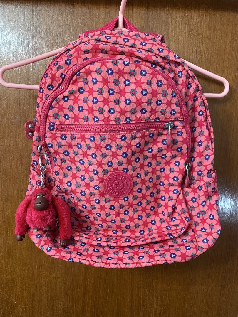 Kipling backpack （分類：背囊）位於 Hong Kong。 由 good.reasonable.deal 提交（商品編號 1438179422，圖片 1）。簡介： 經典的 Kipling 印花雙肩後背包（常規多為 Seoul 或 Clas Seoul 系列款式），採用品牌標誌性的抓皺尼龍材質，並搭配經典的毛絨大猩猩鑰匙圈。產品主要特色幾何印花設計：亮眼的多彩幾何圖形點綴在桃粉色底色上，呈現活潑復古的星形視覺。多功能收納空間：前方設有大拉鍊層與橫式小拉鍊袋，便於分類收納常用小物。招牌毛絨猴：隨包附贈同色系的桃粉色抓皺毛絨大猩猩吊飾。。