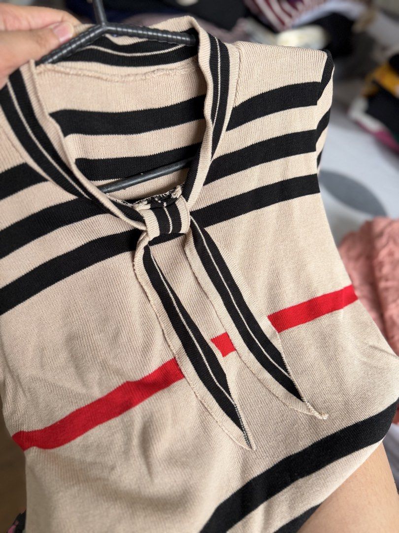 Knitted Striped Soft Knit Top with Tie (Category: Blouses) located in Paranaque City. Submitted by khamsay (Listing ID 1438211719, Image 3). Description: - Beige knit top with black and red stripes - Short sleeves - Tie detail at neckline - Mock neck design - Soft knit material.