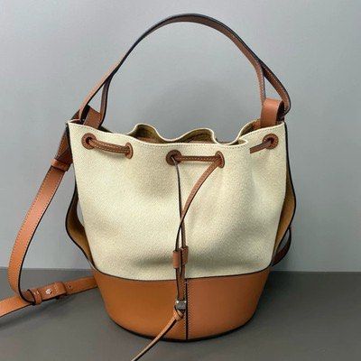 Loewe Bucket Bag with Drawstring Closure (Category: Luxury Bags & Wallets) located in Taguig. Submitted by sourcedbym (Listing ID 1438113122, Image 2). Description: - Loewe bucket bag - Drawstring closure - Tan leather base and trim - Cream canvas body - Includes dust bag - Tan leather handles - Classic and elegant design.