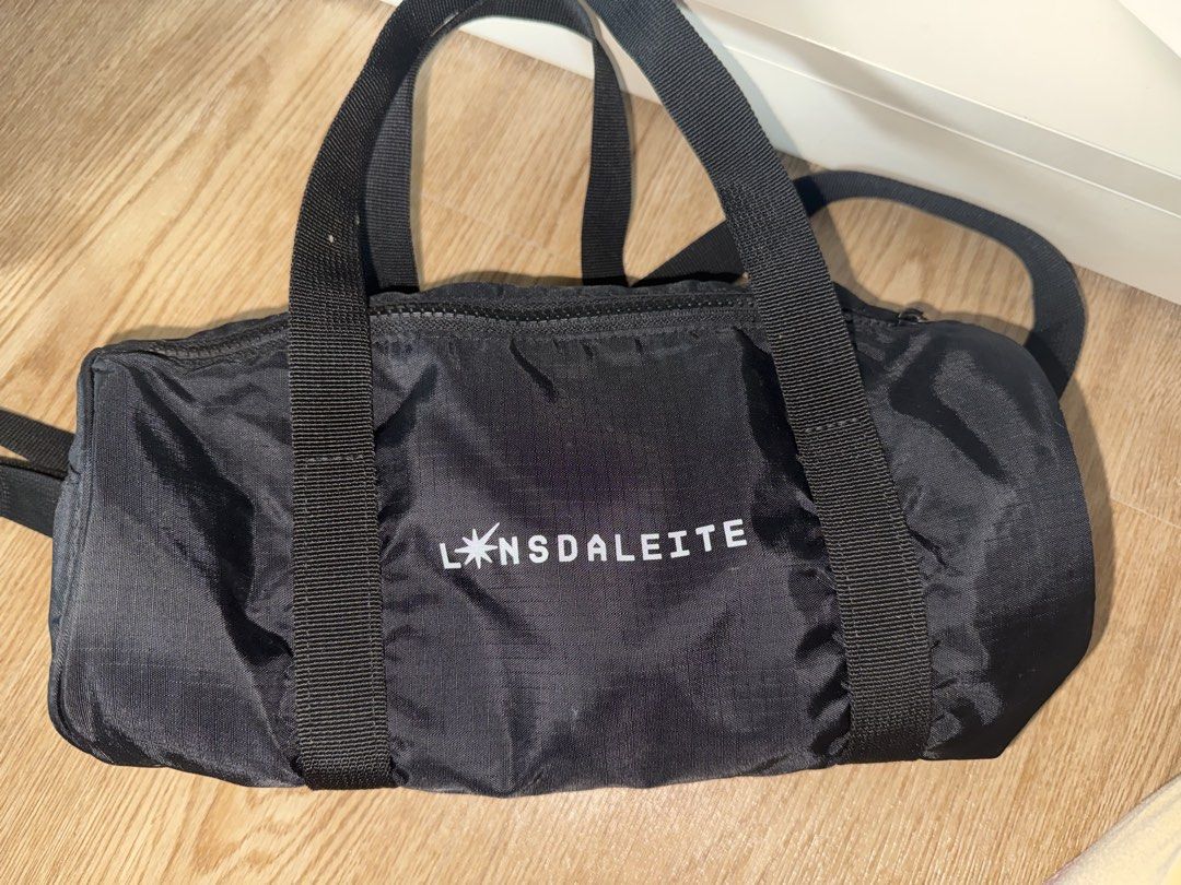 Lonsdaleite Lightstick Pouch | Baekhyun Bag (Category: Luxury Bags & Wallets) located in Quezon City. Submitted by notloey (Listing ID 1438259617, Image 1). Description: - Lonsdaleite duffle bag - Top zipper closure - Dual top handles - Adjustable shoulder strap - Durable, possibly water-resistant material - Cylindrical shape - White star design on the side.