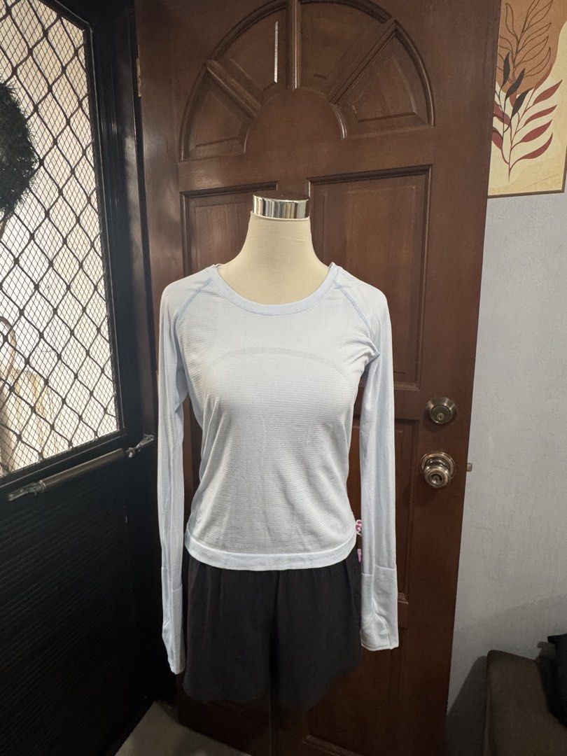 Lululemon Swiftly Tech Long Sleeve Shirt (Category: Activewear) located in Lipa City. Submitted by xanthebrandedprelovesnthrift (Listing ID 1438153728, Image 1). Description: - Lululemon Swiftly Tech long sleeve shirt - Light blue color - Crew neck - Long sleeves with thumbholes - Lululemon logo on back - Slim fit - Breathable, textured fabric - Designed for athletic activities.