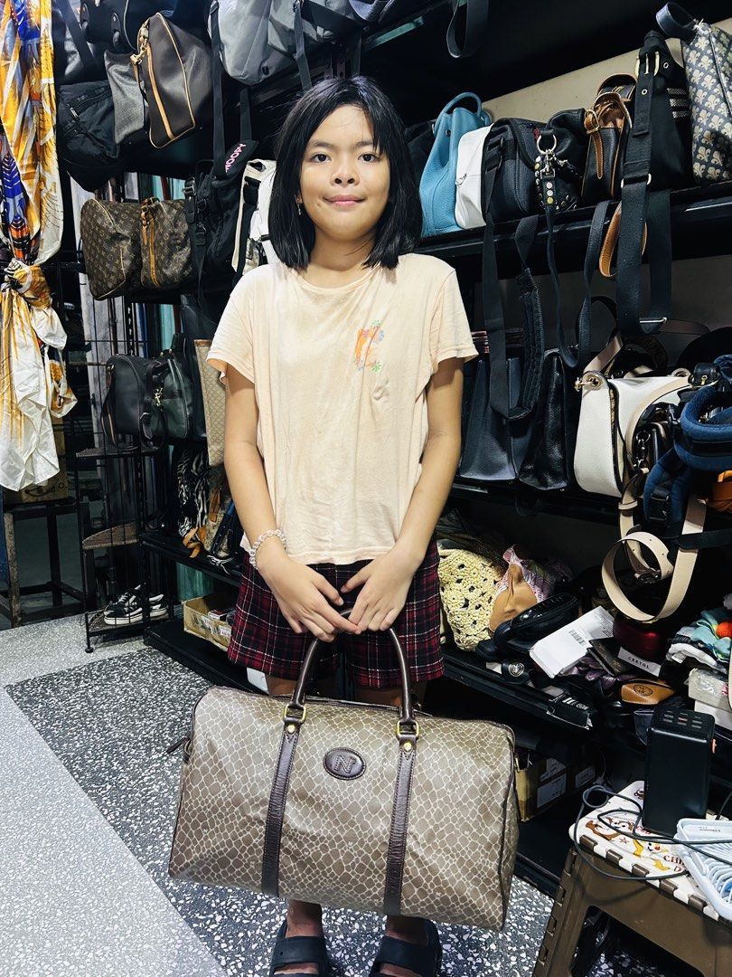 Nina Ricci Travelling Bag (Category: Community) located in Manila. Submitted by starbalesukandjapansurplus (Listing ID 1438277502, Image 2). Description: - Authentic Nina Ricci travel bag - Stylish brown patterned design - Secure top zipper closure - Comfortable dual handles - Elegant brown leather trim - Durable gold-tone hardware - Generous capacity for travel essentials - Features the iconic Nino Cerruti logo.