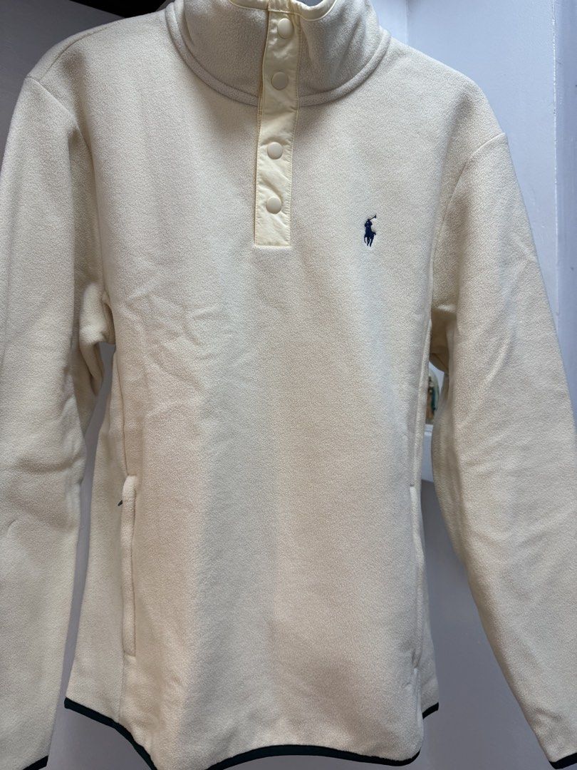 Polo Ralph Lauren Performance Fleece Sweater (Category: Coats, Jackets and Outerwear) located in Caloocan City. Submitted by izzie_finds (Listing ID 1438112031, Image 2). Description: - Polo Ralph Lauren Performance fleece sweater - Color: Cream - Size: Small - Features: - High collar with button closure - Embroidered logo - Side pockets with zippers - Dark green trim on cuffs and hem.