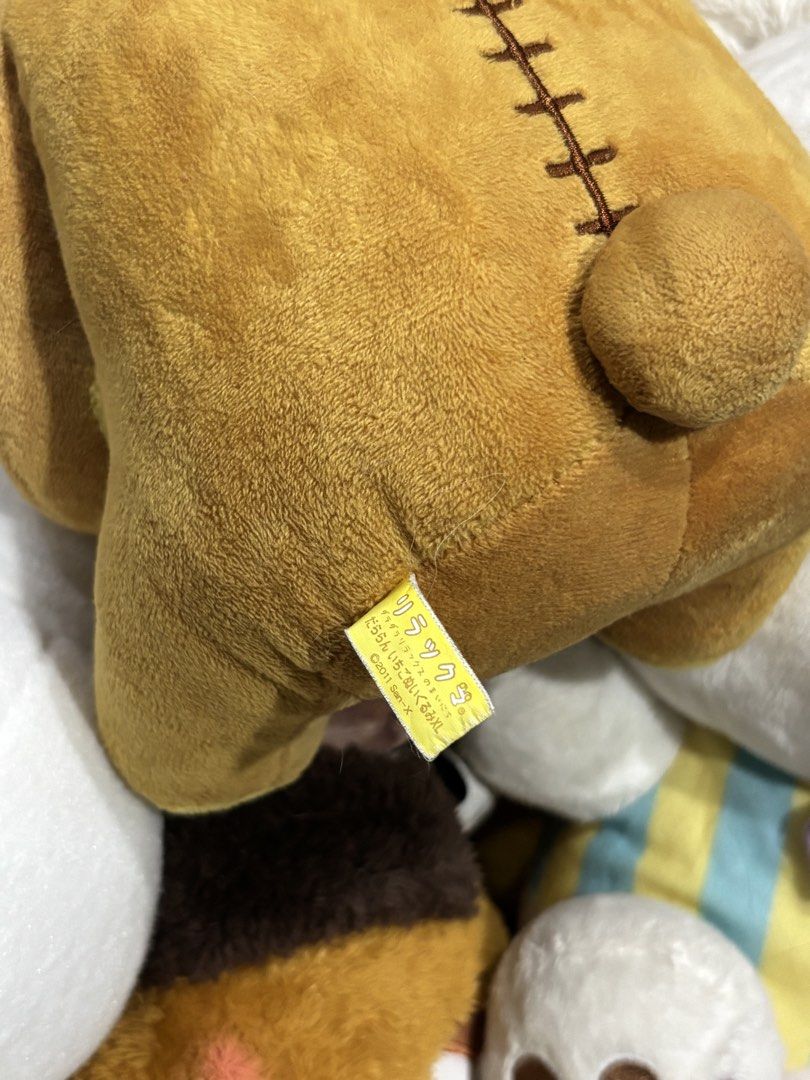 Rilakkuma Strawberry Bear Plush Toy (Category: Plushies & Soft Toys) located in Manila. Submitted by mpt99876 (Listing ID 1438139945, Image 3). Description: Adorable Rilakkuma bear plush toy featuring a strawberry theme. The bear is wearing a strawberry and flower crown and holding a strawberry. The plush has a brown body with yellow accents on the ears and feet. The back of the plush has a stitched design. Includes the original tag..