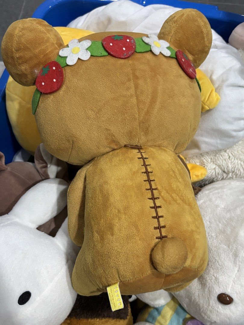 Rilakkuma Strawberry Bear Plush Toy (Category: Plushies & Soft Toys) located in Manila. Submitted by mpt99876 (Listing ID 1438139945, Image 2). Description: Adorable Rilakkuma bear plush toy featuring a strawberry theme. The bear is wearing a strawberry and flower crown and holding a strawberry. The plush has a brown body with yellow accents on the ears and feet. The back of the plush has a stitched design. Includes the original tag..