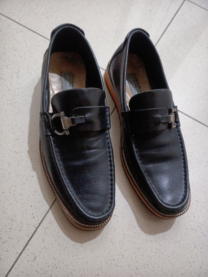 Salvatore Ferragamo Black Loafers (Category: Casual Shoes) located in Digos. Submitted by junior159664 (Listing ID 1438270346, Image 1). Description: - Authentic Salvatore Ferragamo loafers - Color: Black - Size: 41 - Features: Silver buckle detail, orange and grey sole - Made in Italy .