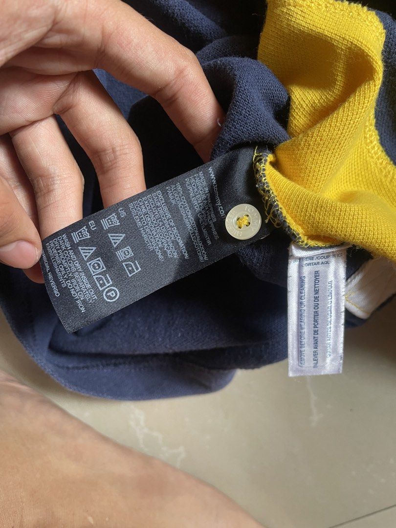 Tommy Hilfiger Polo Shirt (Category: Tshirts & Polo Shirts ) located in Manila. Submitted by cadithrift (Listing ID 1438147541, Image 3). Description: yellow and navy Tommy Hilfiger Custom Fit Polo Shirt with a diagonal cross design and an “85” crest. 20x27 .