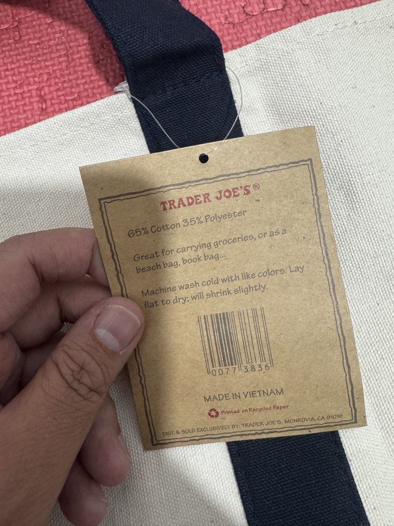 Trader Joe's Canvas Tote Bag (Category: Tote Bags) located in Valenzuela. Submitted by fairythrift (Listing ID 1438138131, Image 3). Description: Trader Joe's tote bag Large Ideal for groceries or beach trips Features a navy blue base and handles Includes a front pocket Features the Trader Joe's logo.