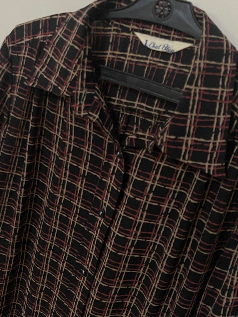 Vintage Plaid Blouse by Chat Bleu (Category: Blouses) located in Santa Cruz. Submitted by lilpurpleseven (Listing ID 1438131178, Image 2). Description: - Vintage plaid blouse - Colors: Black, brown, and red - Long sleeves with buttoned cuffs - Collared neckline - Button-down front - Lightweight material - Brand tag visible - Versatile style.