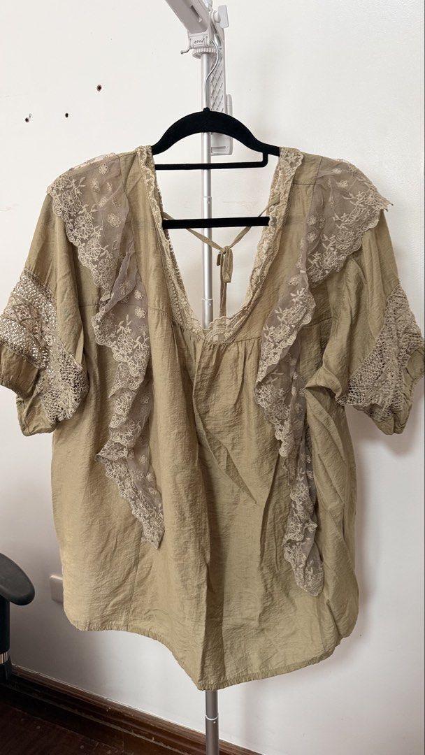 Whimsy Bohemian Style Lace Trim Blouse (Category: Blouses) located in Silang. Submitted by aysbucket (Listing ID 1438128910, Image 1). Description: - Bohemian style blouse - Delicate lace trim - Relaxed fit - Short sleeves - V-neck with tie back - Light, neutral color - Versatile for different outfits.
