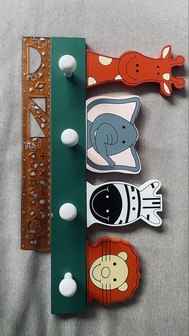 4 Hooks Wildlife Kids Hook Rail MDF (Category: Hooks & Hangers) located in Quezon City. Submitted by smithram (Listing ID 1438360067, Image 1). Description: It has a green MDF wood base with four white cylindrical peg hooks. It features four colorful, cartoon-style jungle animals peeking over the top bar: a giraffe, elephant, zebra, and lion..