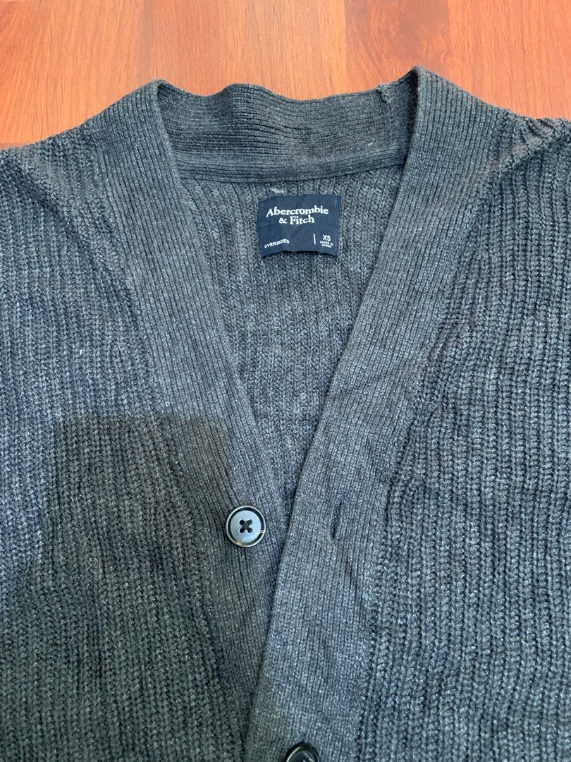 Abercrombie & Fitch Cardigan (Category: Coats, Jackets and Outerwear) located in Makati City. Submitted by gregoniake27981 (Listing ID 1438368616, Image 2). Description: - Abercrombie & Fitch cardigan - Dark grey color - Button-up front - Ribbed knit texture - V-neck - Long sleeves - Medium weight - Great for layering - Versatile design.