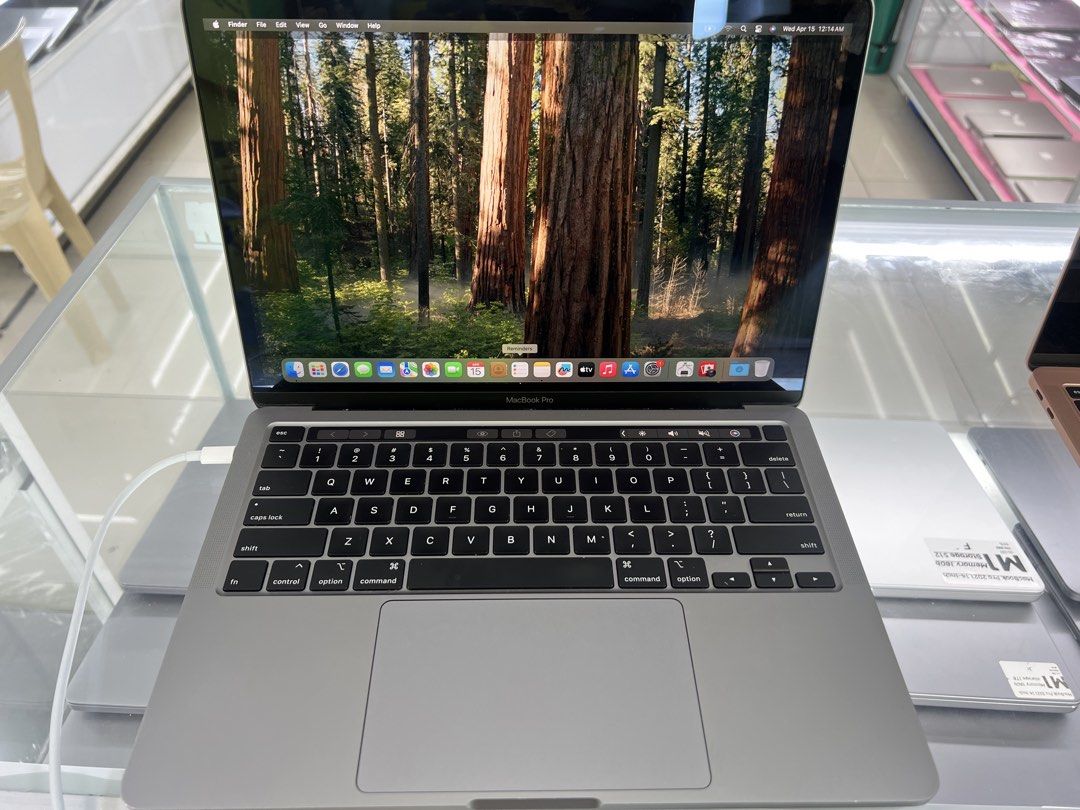 Apple Macbook Pro (Category: Laptops & Notebooks) located in Manila. Submitted by silverowl_01e1cb (Listing ID 1438419237, Image 1). Description: Apple Macbook Pro 2020 i5 13inch laptop. Space gray and a backlit keyboard. The screen displays a forest image. The laptop is open, showing the keyboard and trackpad. The Apple logo is visible on the back. There is a small blue mark on the side..
