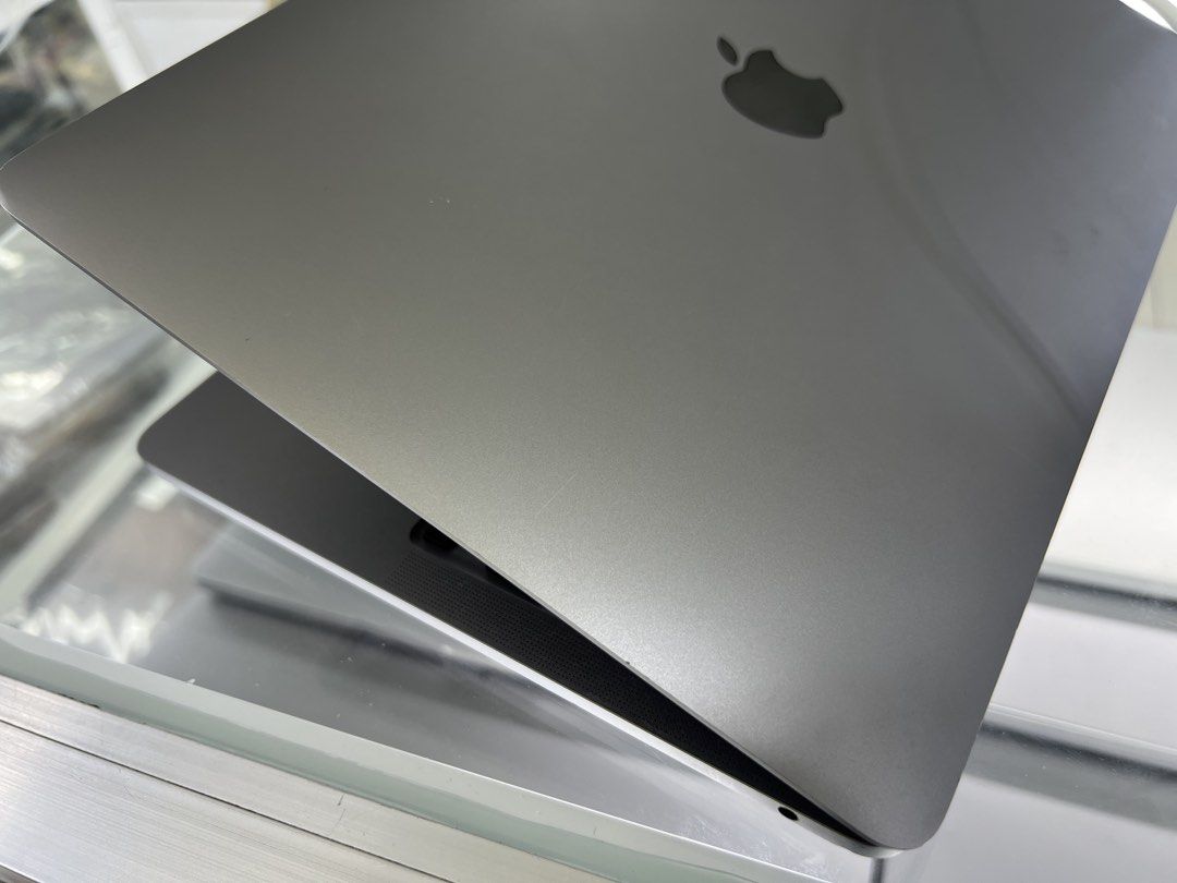 Apple Macbook Pro (Category: Laptops & Notebooks) located in Manila. Submitted by silverowl_01e1cb (Listing ID 1438419237, Image 3). Description: Apple Macbook Pro 2020 i5 13inch laptop. Space gray and a backlit keyboard. The screen displays a forest image. The laptop is open, showing the keyboard and trackpad. The Apple logo is visible on the back. There is a small blue mark on the side..