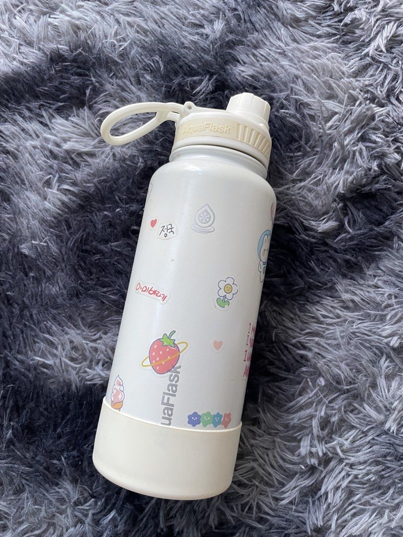AquaFlask Water Bottle with Stickers (Category: Water Bottles & Tumblers) located in Manila. Submitted by izxbll_declutters (Listing ID 1438500495, Image 1). Description: - White AquaFlask water bottle - Adorned with cute stickers (strawberry and flower designs) - Matching white lid and base - Features a convenient handle - Standard size, perfect for everyday use.