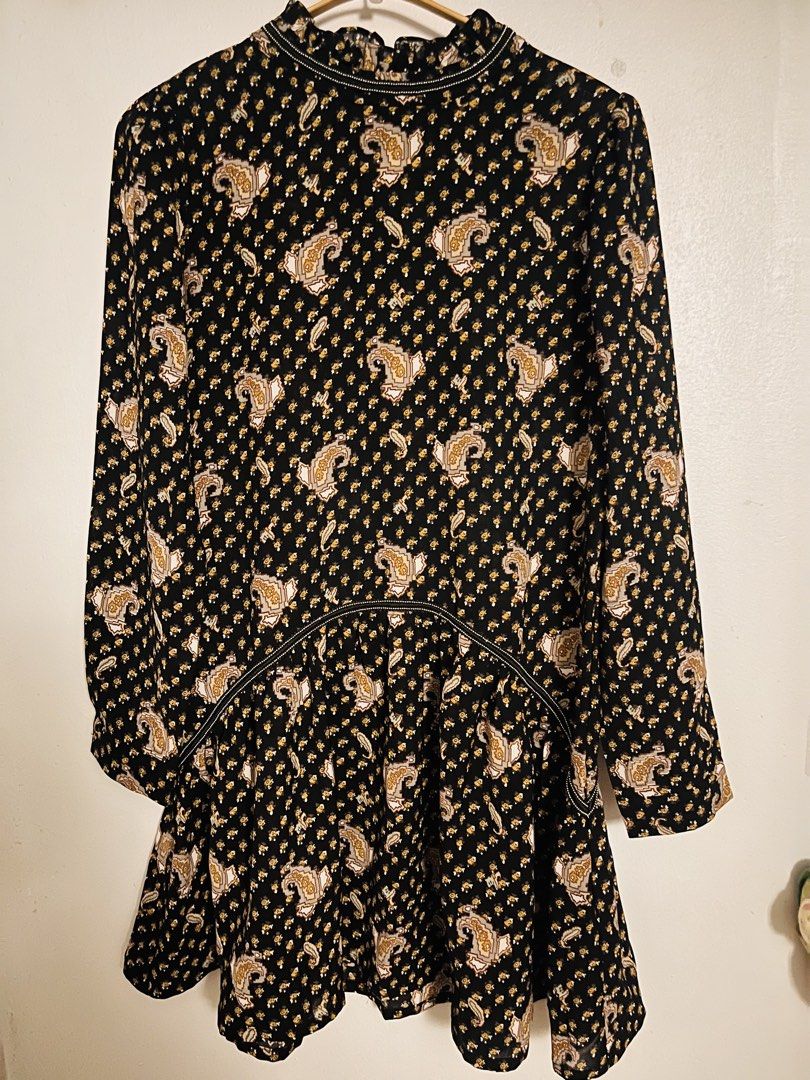 BLACK PAISLEY DRESS (Category: Dresses) located in Pasig City. Submitted by fruitselling (Listing ID 1438429008, Image 2). Description: - Neckline: High ruffled or funnel mock neck lined with piping detail. - Sleeves: Long sleeves with elasticated smocked cuffs. - Waistline: Curved piping seam that drops into an elasticated smocked waist. - Skirt: Tiered A-line silhouette featuring lightweight ruffled panels. Width 17 inches Length 31 inches .