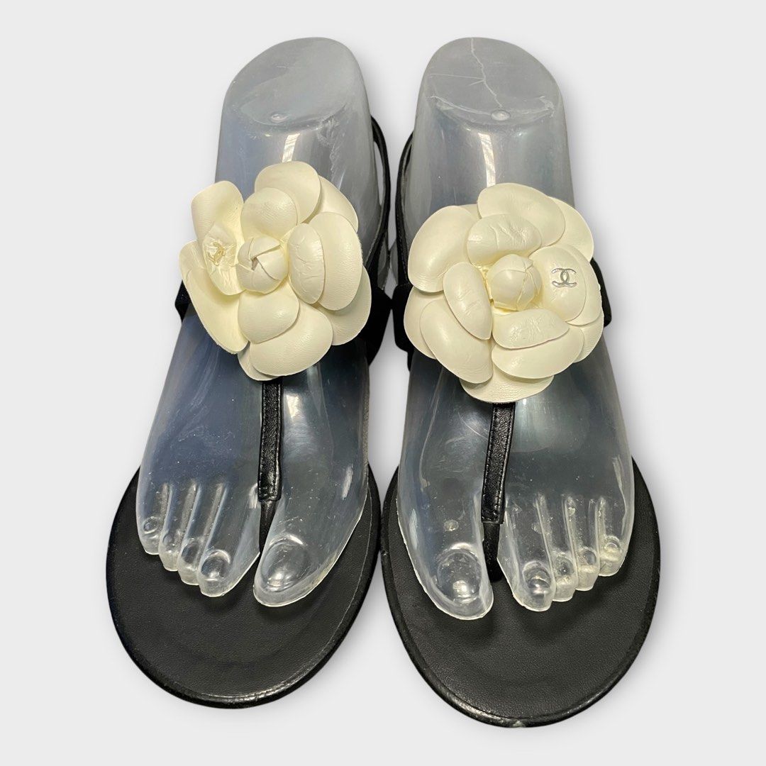 Chanel - Camellia CC Flat Leather Sandals (Category: Flats & Sandals) located in Los Banos. Submitted by declutterking (Listing ID 1438489336, Image 2). Description: Size 38C This summer, give an edge to your outfit by stepping out in these thong sandals from the house of Chanel. Crafted from black leather, this pair features a t-strap and buckle fastening at the ankle. The pair is complete with a CC-adorned Camellia flower on the front. Pair onl
