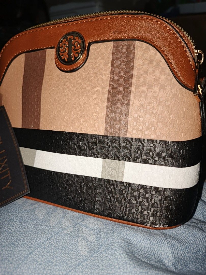 Deluxity Los Angeles Small, Sling Bag (Category: Cross-body Bags) located in Manila. Submitted by princee08 (Listing ID 1438486402, Image 2). Description: - Deluxity Los Angeles Crossbody Bag - Color scheme: Brown, Tan, and Black - Gold chain strap - Striped interior - Decorative emblem on front - Zipper closure - Brand new with tag - With slight flaw, pls see pic P1500 only LOC: Manila PM if interested.