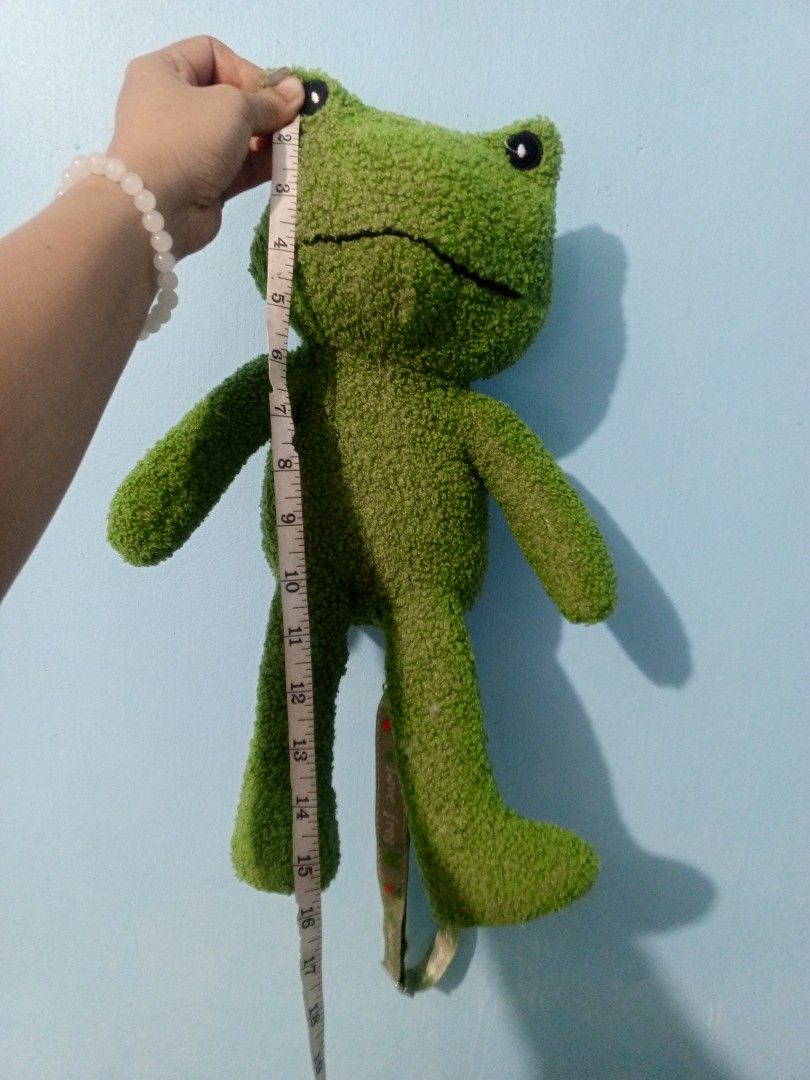 Frog Plush Backpack (Category: Plushies & Soft Toys) located in Manila. Submitted by alengmaliit (Listing ID 1438366039, Image 3). Description: - Adorable frog plush backpack! - Features a green, textured exterior. - Convenient zipper closure on the back. - Adjustable straps for a comfortable fit. - Cute frog face design. - Perfect for kids and frog lovers! - Approximately 16 inches in height. -Actual photos posted. Issue: Missing one strap 📍Loc