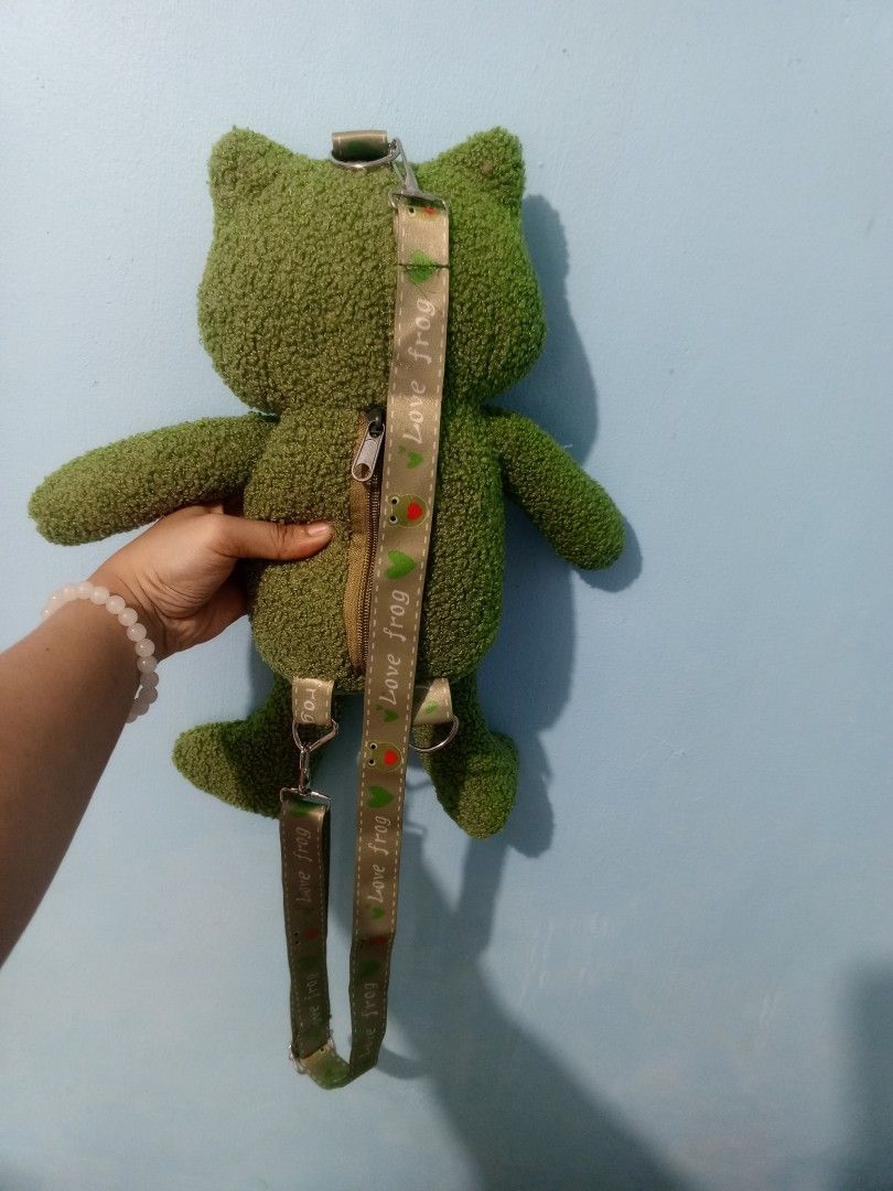 Frog Plush Backpack (Category: Plushies & Soft Toys) located in Manila. Submitted by alengmaliit (Listing ID 1438366039, Image 2). Description: - Adorable frog plush backpack! - Features a green, textured exterior. - Convenient zipper closure on the back. - Adjustable straps for a comfortable fit. - Cute frog face design. - Perfect for kids and frog lovers! - Approximately 16 inches in height. -Actual photos posted. Issue: Missing one strap 📍Loc