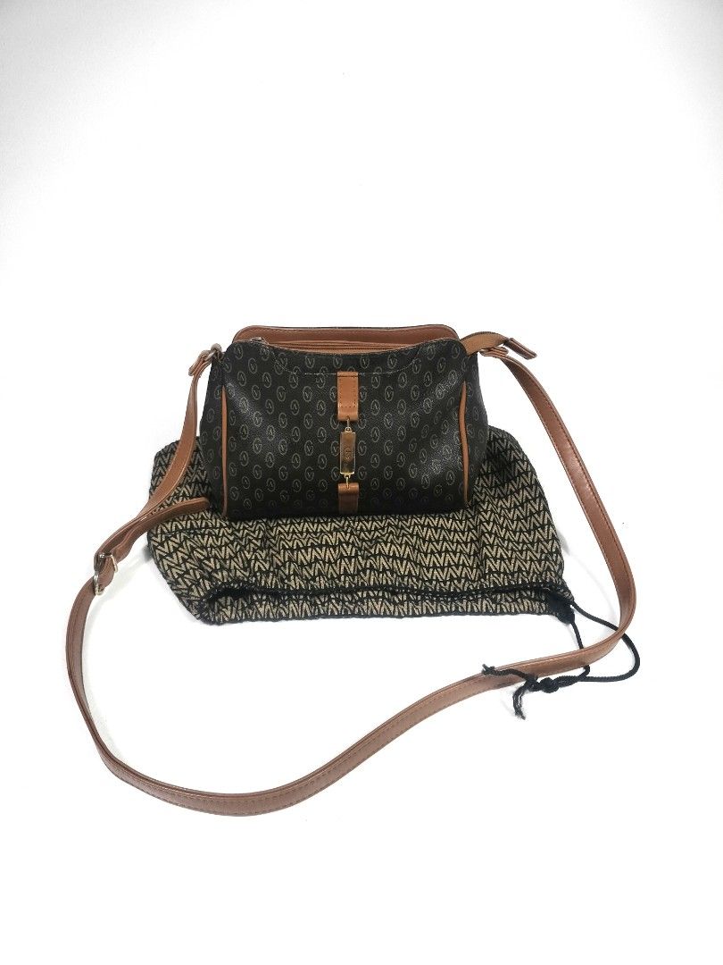Gianni Valentino Crossbody Bag (Category: Luxury Bags & Wallets) located in Manila. Submitted by callmetin (Listing ID 1438428306, Image 1). Description: - Gianni Valentino crossbody bag - Brown monogram pattern with leather accents - Includes dust bag - Top zipper closure - Adjustable shoulder strap - Lined interior - Gold-tone metal logo detail.