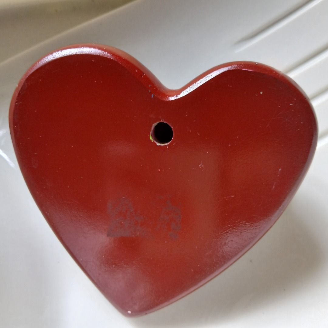 Heart-Shaped Ornament with Wings (Category: Other Home Decor) located in Pasig City. Submitted by arlafontam89410 (Listing ID 1438362120, Image 2). Description: Heart-shaped ornament features the words "N2 Heaven on Earth" and small wings on either side. The ornament is a deep red color. There is a hole on the back, suggesting it can be hung. It is a unique decorative piece..