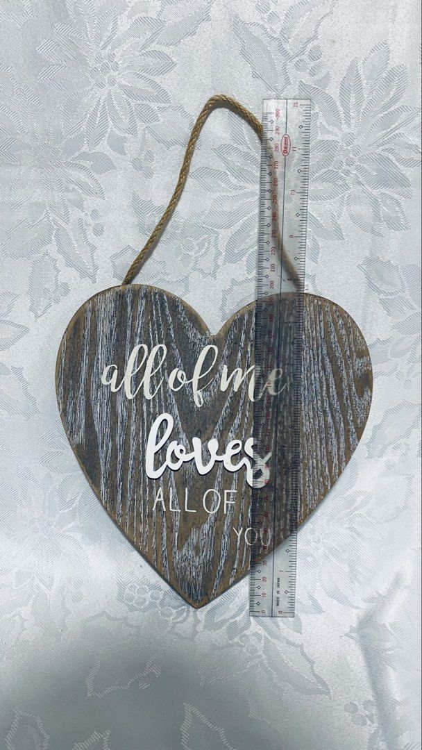 Heart-Shaped Wooden Wall Decor (Category: Wall Decor) located in Quezon City. Submitted by smithram (Listing ID 1438325154, Image 1). Description: - Heart-shaped wooden wall decor - Features the quote "all of me loves all of you" - Rustic, distressed finish - Includes jute rope for easy hanging - Approximately 10 inches in height - Comes with care instructions sticker.