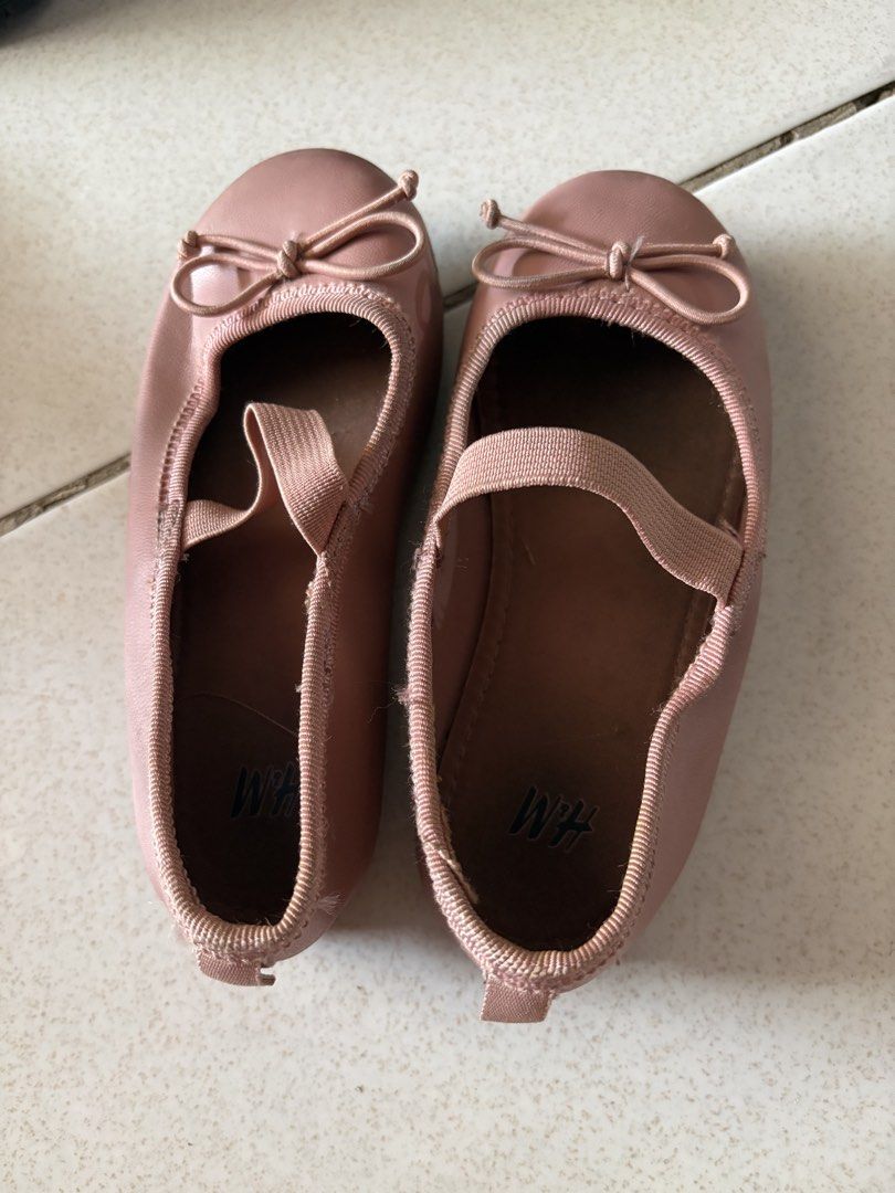 H&M Ballet Flats (Category: Babies & Kids Fashion) located in Pasig City. Submitted by shenzi83 (Listing ID 1438440275, Image 1). Description: These ballet flats from H&M are a lovely shade of pink. They feature a bow detail on the front and an elastic strap for a secure fit. The shoes have a classic ballet flat design, perfect for everyday wear. The H&M logo is visible inside the shoe..