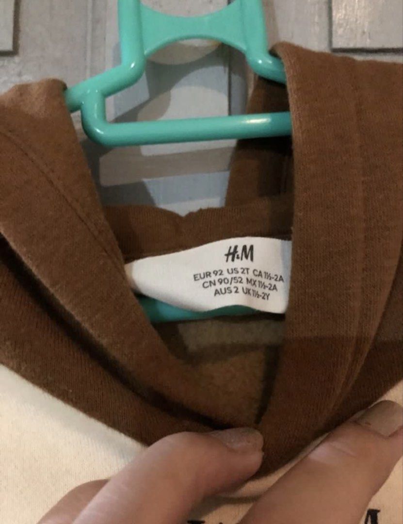 H&M Kids Hoodie (Category: Babies & Kids Fashion) located in Samal. Submitted by dettyp (Listing ID 1438363250, Image 2). Description: - H&M kids hoodie - Size: 2T - Color block design: Brown and cream - Features a front pocket - Includes a hood - Front print: "NEW YORK. LONDON. STOCKHOLM. TOKYO.".
