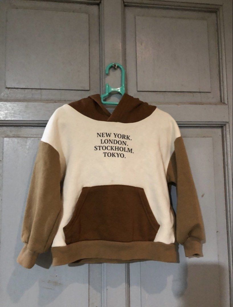 H&M Kids Hoodie (Category: Babies & Kids Fashion) located in Samal. Submitted by dettyp (Listing ID 1438363250, Image 1). Description: - H&M kids hoodie - Size: 2T - Color block design: Brown and cream - Features a front pocket - Includes a hood - Front print: "NEW YORK. LONDON. STOCKHOLM. TOKYO.".