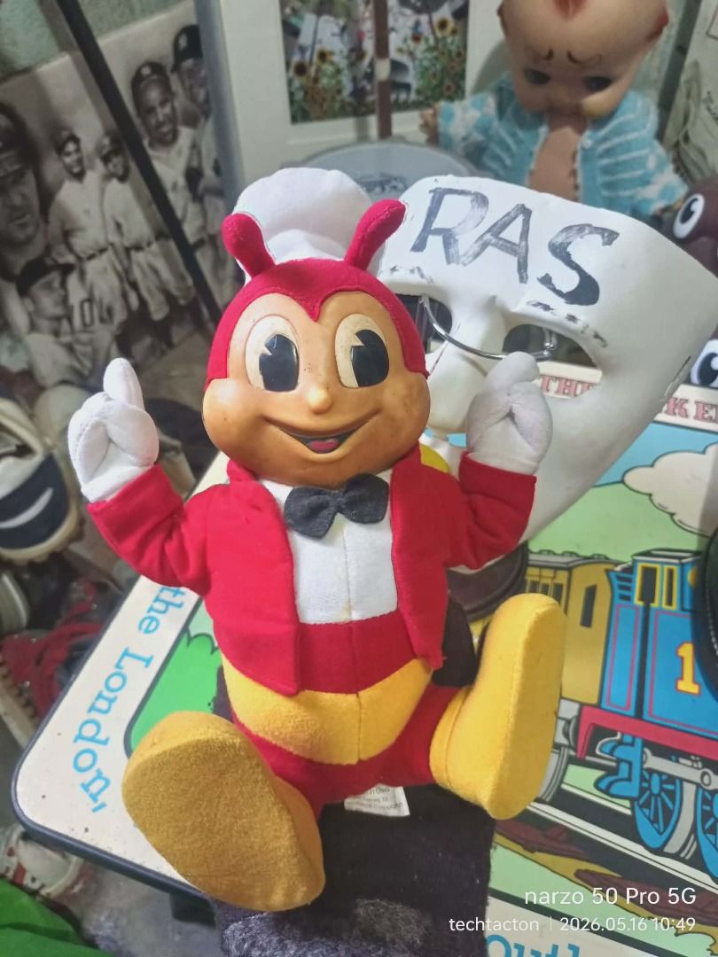 Jollibee Plush Toy (Category: Plushies & Soft Toys) located in Santo Tomas. Submitted by pickers_corner (Listing ID 1438381606, Image 1). Description: vintage 90s Jollibee Doll Rare Vinyl Plushie h26cm standing position needs cleaning as is Jollibee plush toy features the iconic mascot in its classic outfit. It has a red jacket, yellow legs, and a white chef's hat. The tag indicates it was made in China exclusively for Jollibee Foods Corporation.