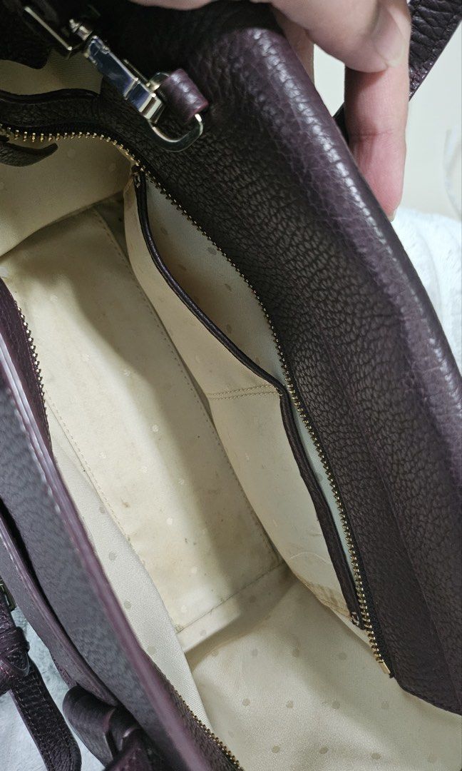 Kate Spade New York Handbag (Category: Luxury Bags & Wallets) located in Pasig City. Submitted by shopwithnic (Listing ID 1438401189, Image 3). Description: - Kate Spade handbag - Structured design - Deep purple exterior with textured finish - Top handles and detachable shoulder strap - Main compartment with zipper closure - Interior pocket - Light beige interior lining - Includes Kate Spade tag.