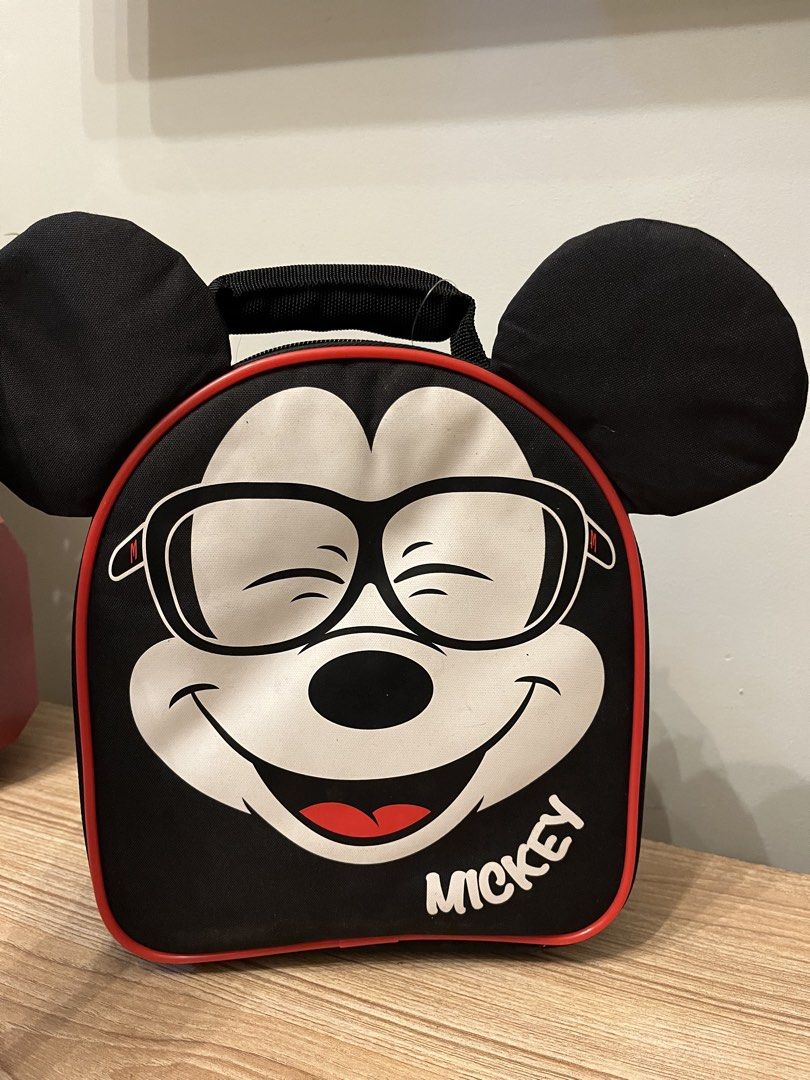M&S Kids Mickey Mouse Lunch Bag (Category: Babies & Kids Fashion) located in Quezon City. Submitted by metamerchant (Listing ID 1438447218, Image 1). Description: - M&S Kids Mickey Mouse lunch bag - Fun Mickey Mouse design with attached ears - Black exterior with red trim - Insulated with 3M Thinsulate - Includes a handle for easy carrying -Size: 24cm x 20cm - Features a small pocket - Comes with M&S Kids tag.