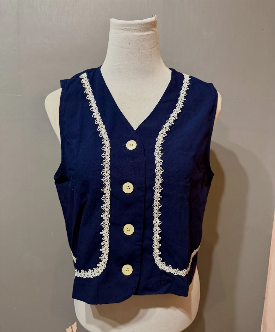 Navy Blue Vest with White Trim (Category: Sleeveless) located in Davao. Submitted by iahleah (Listing ID 1438475068, Image 1). Description: - Size: Small-Medium Frame - Navy blue vest - V-neck design - White trim detailing - Cream-colored button closure (4 buttons) - Sleeveless - Woven fabric - Classic style.