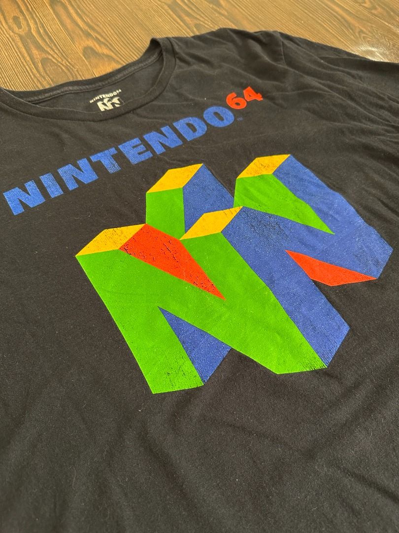 Nintendo 64 Logo Graphic Shirt (Category: Tshirts & Polo Shirts ) located in Santa Rosa. Submitted by younoanco (Listing ID 1438474008, Image 3). Description: Nintendo 64 Logo Graphic Shirt Size: Large Pit to Pit: 21 inches Length: 27.5 inches With minor crack prints.
