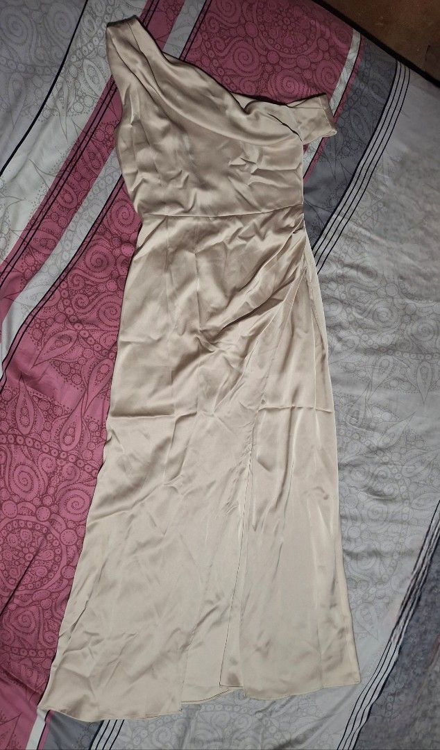 One-Shoulder Satin Maxi Dress (Category: Dresses) located in Lipa City. Submitted by kathethings (Listing ID 1438321315, Image 3). Description: - Elegant champagne maxi dress - One-shoulder design - Flattering draped neckline - High slit - Fitted bodice, flowing skirt - Smooth, satin-like fabric - Ideal for special events A 36-inch bust and 30-inch waist Women's Size 10 Medium to Large in standard apparel sizing..
