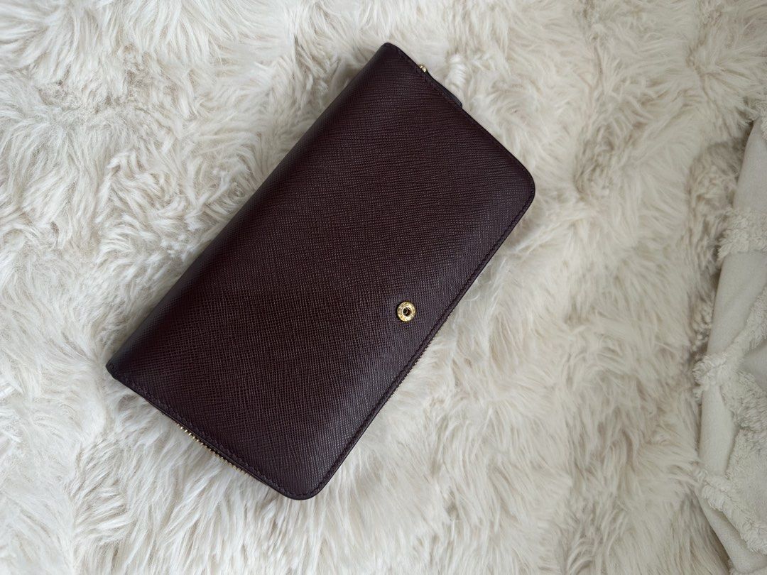 Prada Saffiano Leather Zip Around Wallet (Category: Luxury Bags & Wallets) located in Quezon City. Submitted by reginapakaiguecristobal (Listing ID 1438350471, Image 2). Description: - Authentic Prada wallet - Rich burgundy color - Made of Saffiano leather - Zip-around closure - Snap closure - Prada logo on front - Includes Prada card.