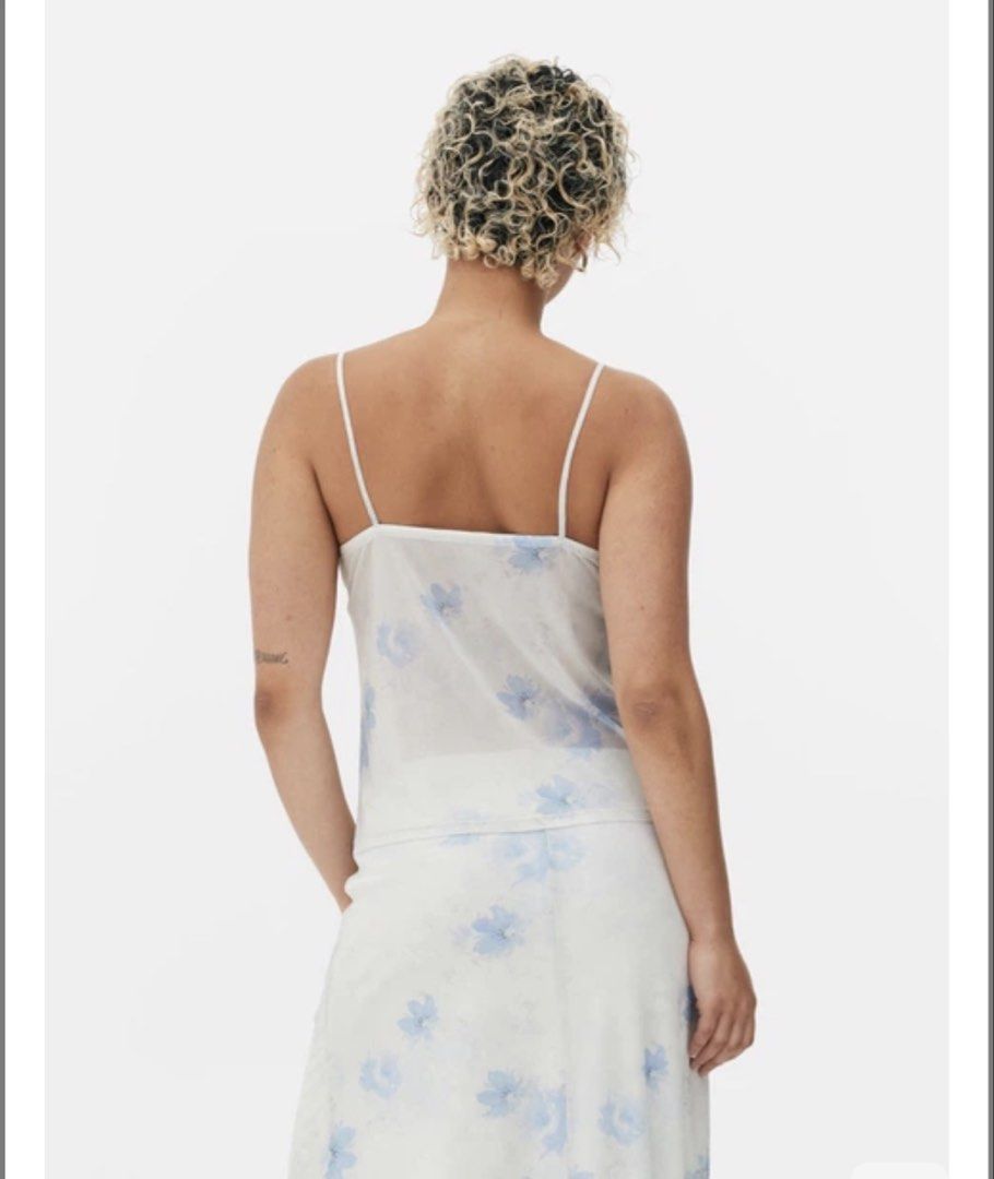 Primark Beach Summer Floral Tie-Front Top (Category: Blouses) located in Pateros City. Submitted by evenings_ (Listing ID 1438485970, Image 3). Description: - Double fabric on the bust part so it’s not see through - Primark floral top, size M. - Delicate floral print with a tie-front design. - Features spaghetti straps and a sheer overlay. - Lightweight fabric, ideal for warm weather. - White base with blue floral details. - Made in Turkey..