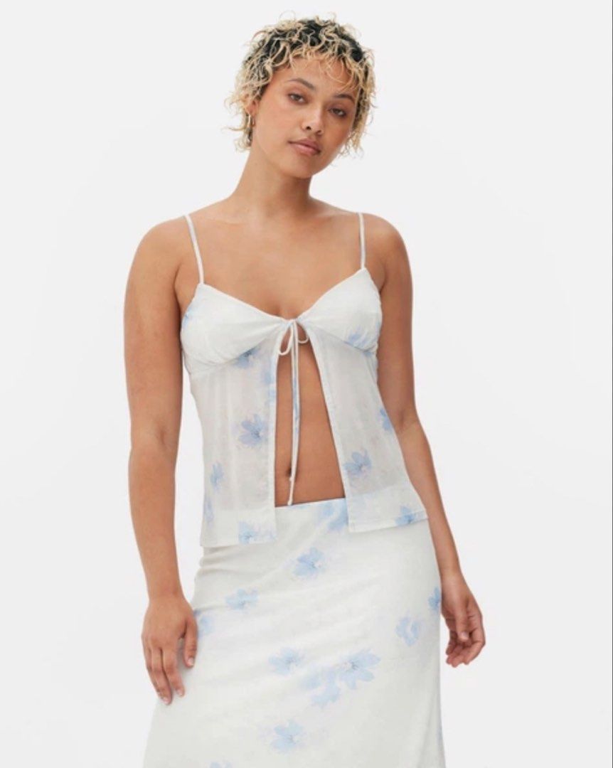 Primark Beach Summer Floral Tie-Front Top (Category: Blouses) located in Pateros City. Submitted by evenings_ (Listing ID 1438485970, Image 1). Description: - Double fabric on the bust part so it’s not see through - Primark floral top, size M. - Delicate floral print with a tie-front design. - Features spaghetti straps and a sheer overlay. - Lightweight fabric, ideal for warm weather. - White base with blue floral details. - Made in Turkey..
