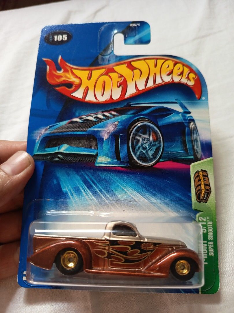 RARE Hot Wheels Treasure Hunt Rubber Wheels (Category: Vehicle & Diecast Models) located in Muntinlupa City. Submitted by toys-22 (Listing ID 1438376313, Image 1). Description: - Hot Wheels - Color: Brown and silver - Features gold-colored wheels - Flame graphics on the side - Part of the Super Smooth series (5/12) - Packaging includes Hot Wheels logo and number 105.