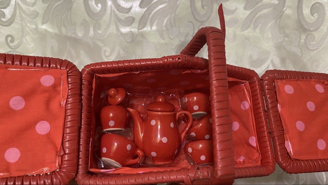 Red Wicker Picnic Basket with Tea Set (Category: Storage Boxes & Baskets) located in Manila. Submitted by 3asonlineshop (Listing ID 1438371146, Image 2). Description: Charming red wicker picnic basket includes a complete tea set. The set features a teapot, cups, saucers, and spoons, all in a matching red color with white polka dots. The basket has a handle and opens to reveal the tea set inside. The interior is lined with red fabric with pink pol