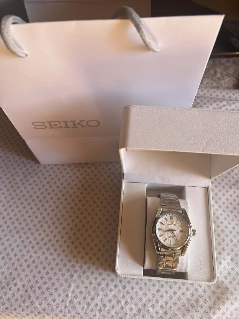 Seiko Grand Seiko Watch (Category: Luxury Watches) located in Manila. Submitted by danielekurt_ (Listing ID 1438477515, Image 3). Description: - Grand Seiko watch - Silver stainless steel bracelet - White dial - Includes box, paper bag, and watch case - Date display - Textured dial.