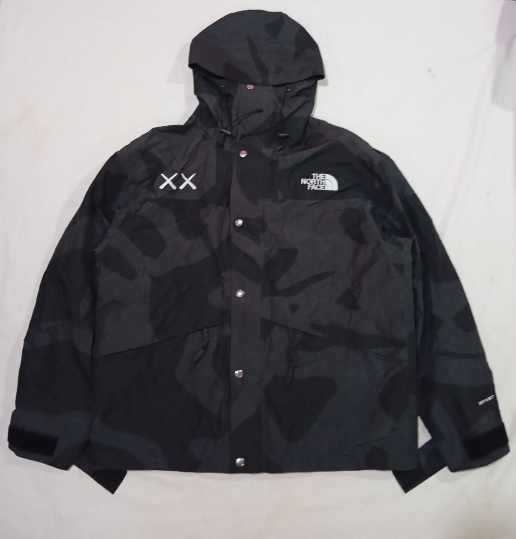 KAWS x The North Face Retro 1986 Mountain Jacket (Category: Coats, Jackets and Outerwear) located in Cagayan de Oro. Submitted by hustlefinds (Listing ID 1438355378, Image 1). Description: KAWS x The North Face Retro 1986 Mountain Jacket in black featuring an abstract camouflage pattern. Brand new condition.