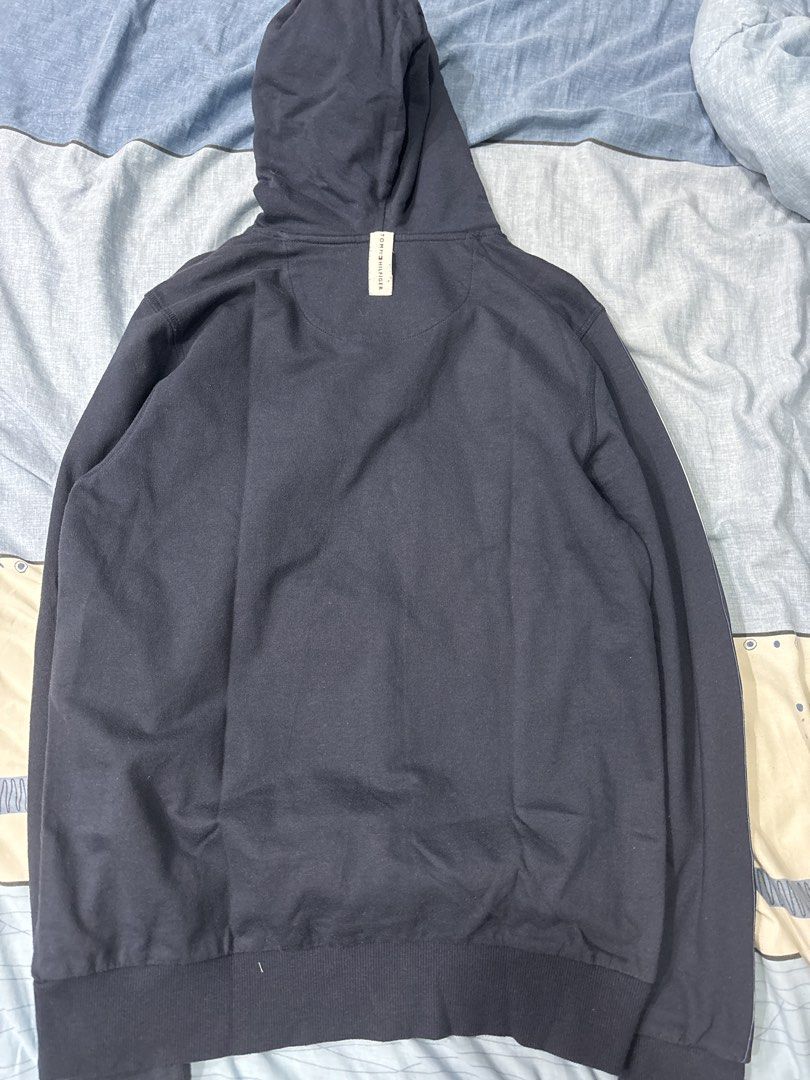 Tommy Hilfiger Hoodie (Category: Hoodies) located in Manila. Submitted by colin92421 (Listing ID 1438472782, Image 2). Description: - Navy blue Tommy Hilfiger hoodie - Features a hood with drawstring - White and red stripes on the sleeves - Tommy Hilfiger logo on the chest - Ribbed hem and cuffs - Plain navy blue back - Authentic Tommy Hilfiger (see tag).