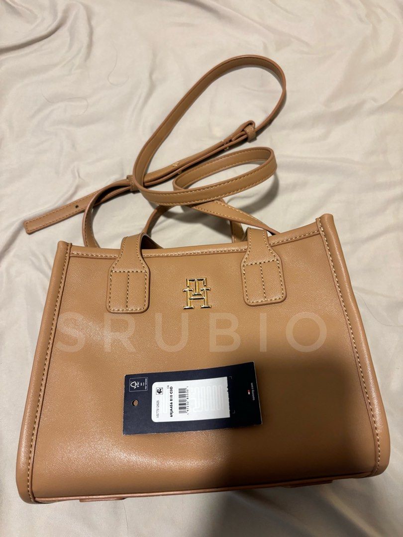 Tommy Hilfiger Tan Tote Bag (Category: Tote Bags) located in General Trias. Submitted by sarahrd (Listing ID 1438431059, Image 2). Description: - Tommy Hilfiger tote bag - Tan color - Gold-tone logo - Top handle - Small interior pocket - Rectangular shape - Includes original tag.