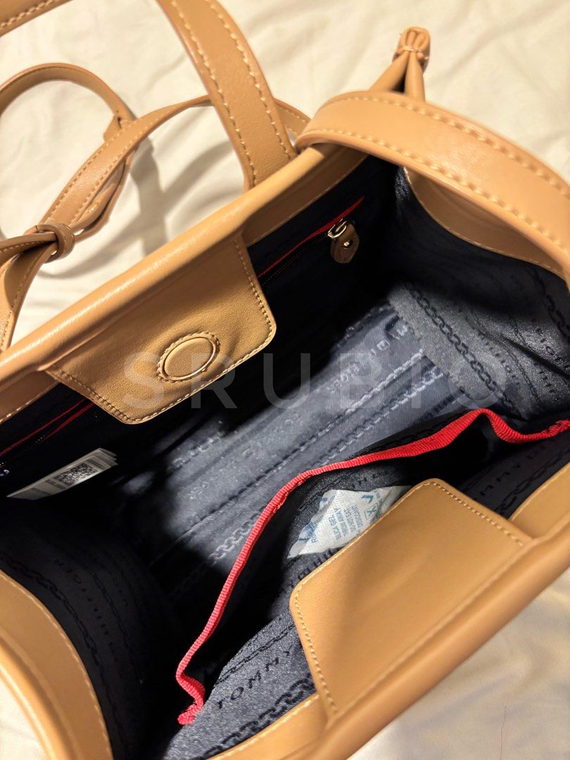 Tommy Hilfiger Tan Tote Bag (Category: Tote Bags) located in General Trias. Submitted by sarahrd (Listing ID 1438431059, Image 3). Description: - Tommy Hilfiger tote bag - Tan color - Gold-tone logo - Top handle - Small interior pocket - Rectangular shape - Includes original tag.