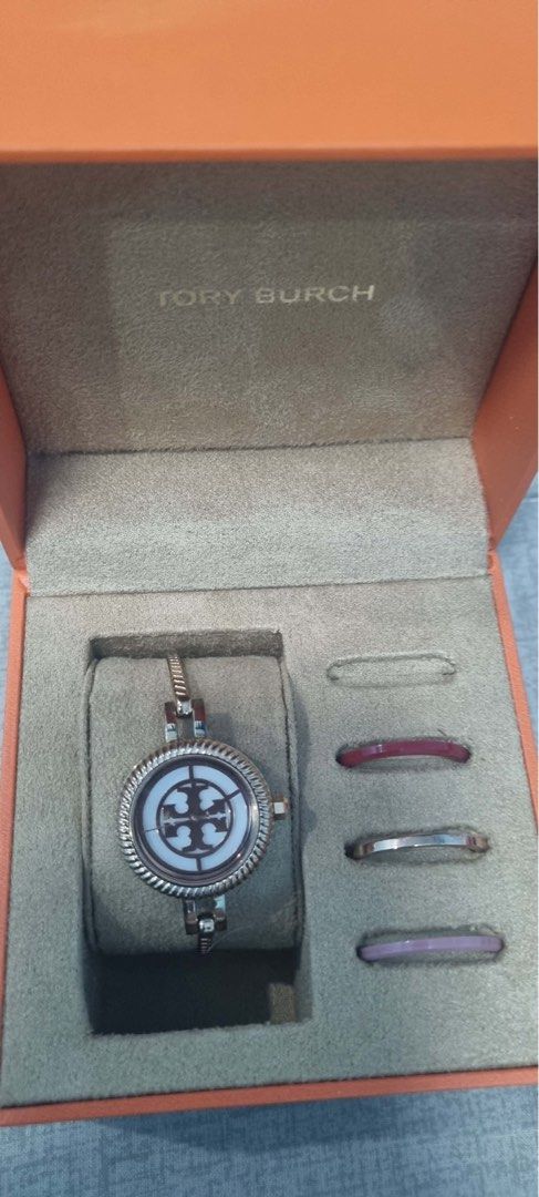 Tory Burch Watch with Rings (Category: Women's Watches) located in Manila. Submitted by ymlrn (Listing ID 1438380811, Image 1). Description: Tory Burch watch set. Includes a silver-tone watch with the Tory Burch logo and three rings (pink, silver, lavender). Comes in an orange box..