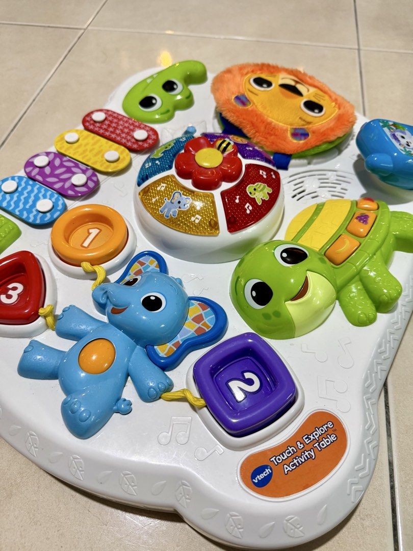 VTech Touch & Explore Activity Table (Category: Infant Playtime) located in Petaling Jaya. Submitted by ywwwe (Listing ID 1438415124, Image 2). Description: - VTech Touch & Explore Activity Table - Interactive features: animal figures, number buttons, xylophone - Detachable slide included - Musical component - Bright, engaging colors - Includes a hanging toy - Designed for toddlers' entertainment and education.